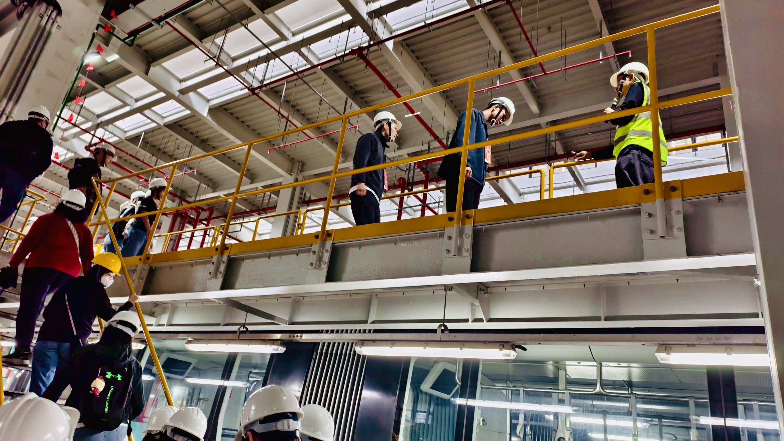 參與者戴安全帽行走在淡海機廠維修工作平台