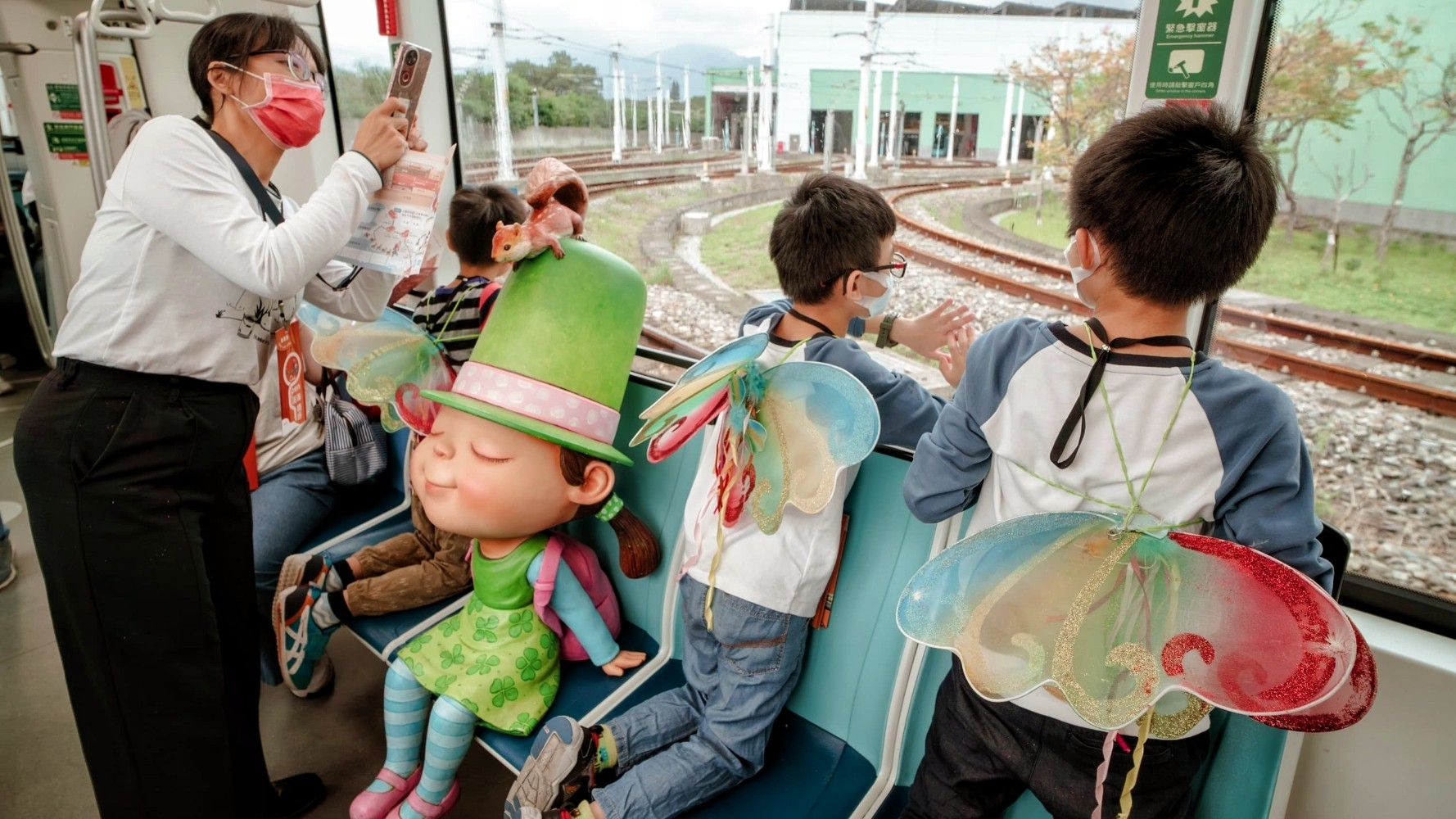 孩子在淡海輕軌車廂內看向窗外機廠軌道