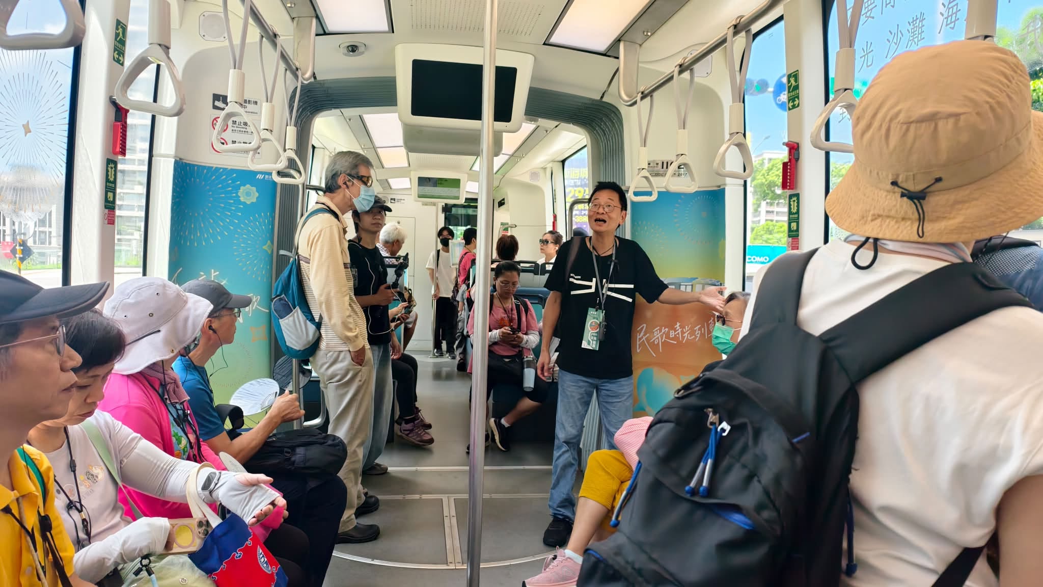 導覽老師在淡海輕軌車廂內向參與者解說沿線地方故事
