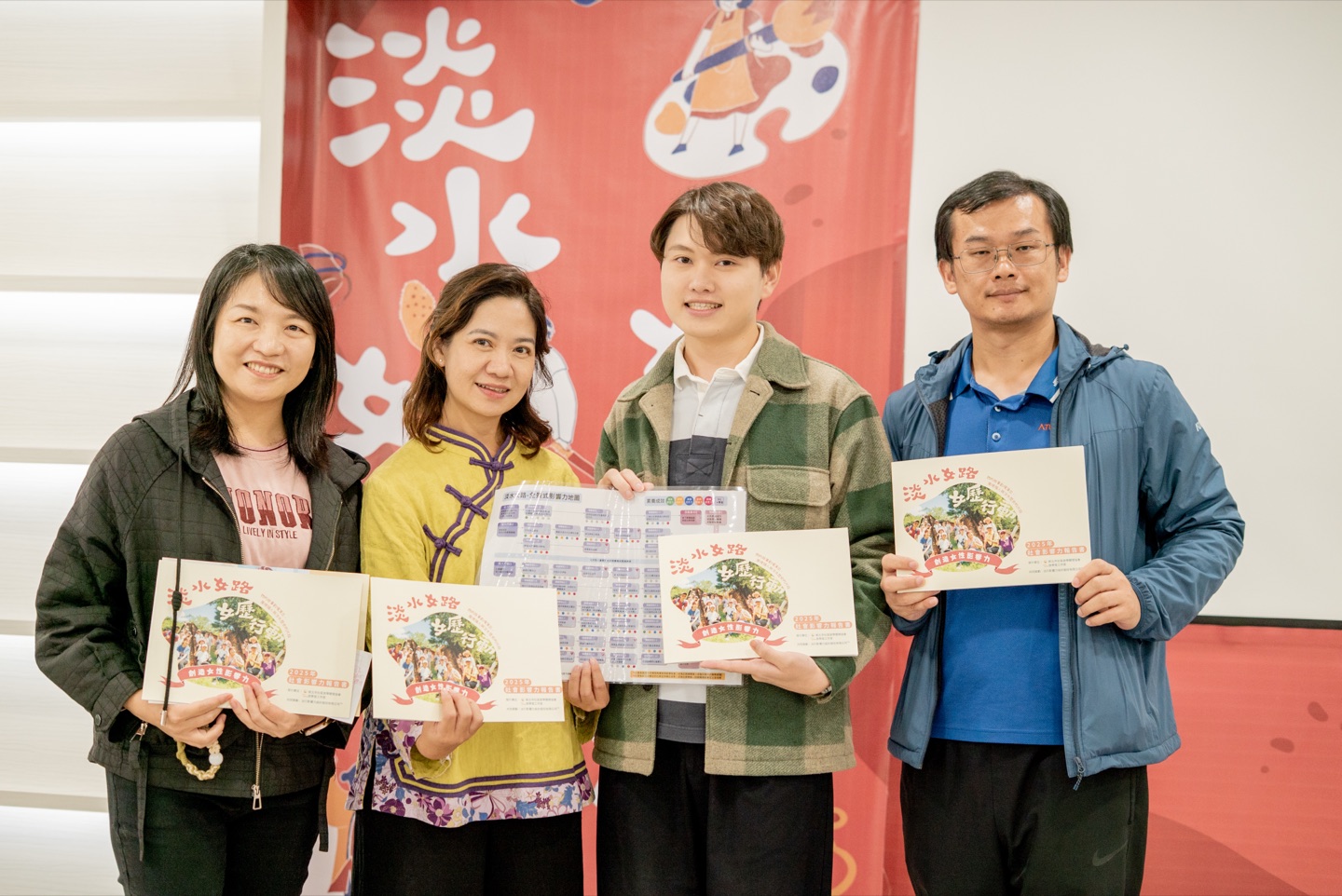 淡水女路團隊與夥伴手持女性影響力報告書合影